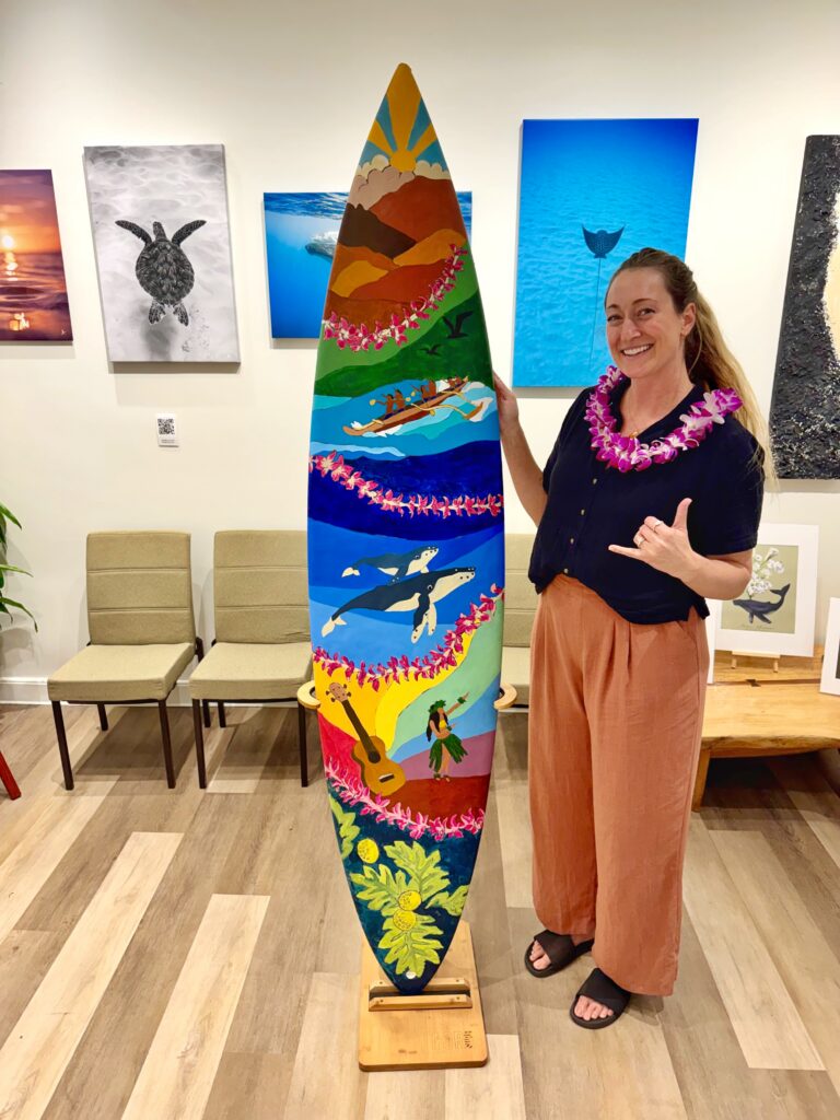 Artist in Residence at Ritz-Carlton in Maui showcasing finished community surfboard project.