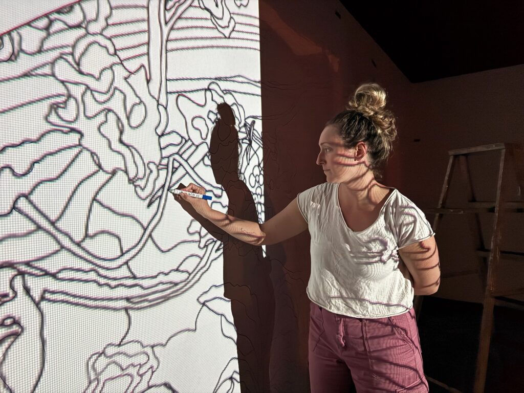 Hawaii mural artist at work tracing mural.