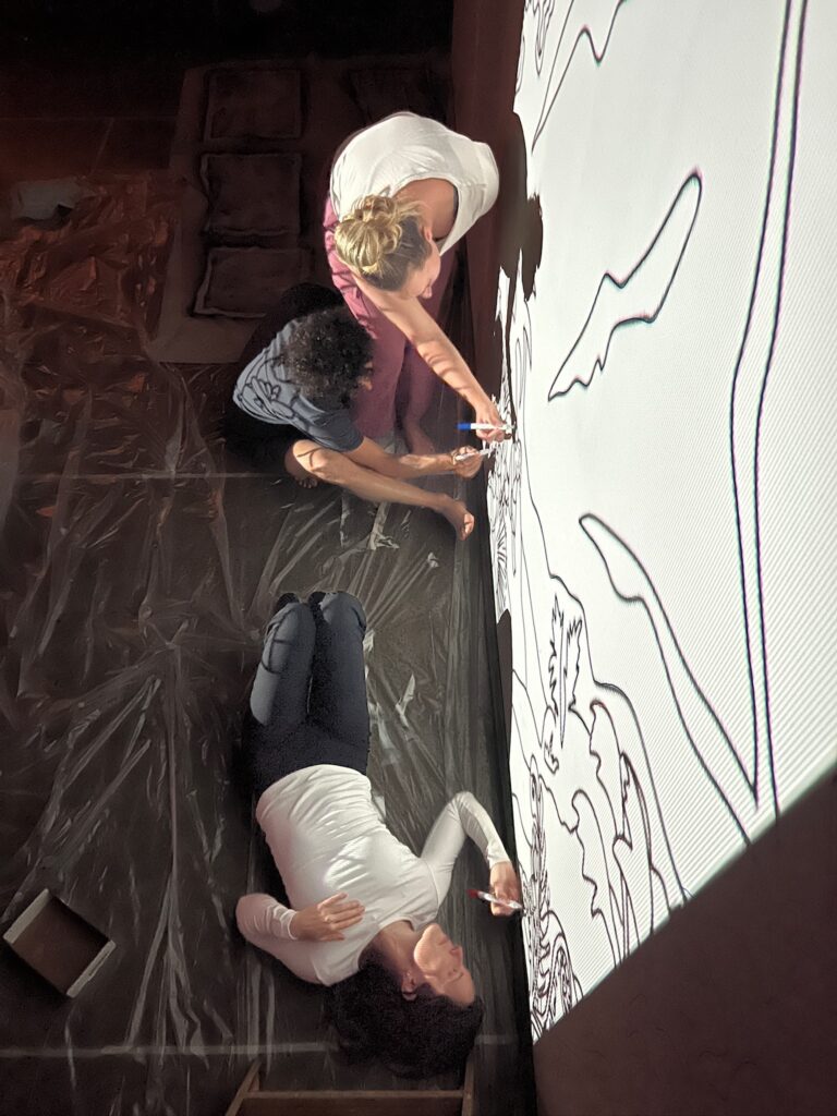 Maui business owners trace mural onto walls.