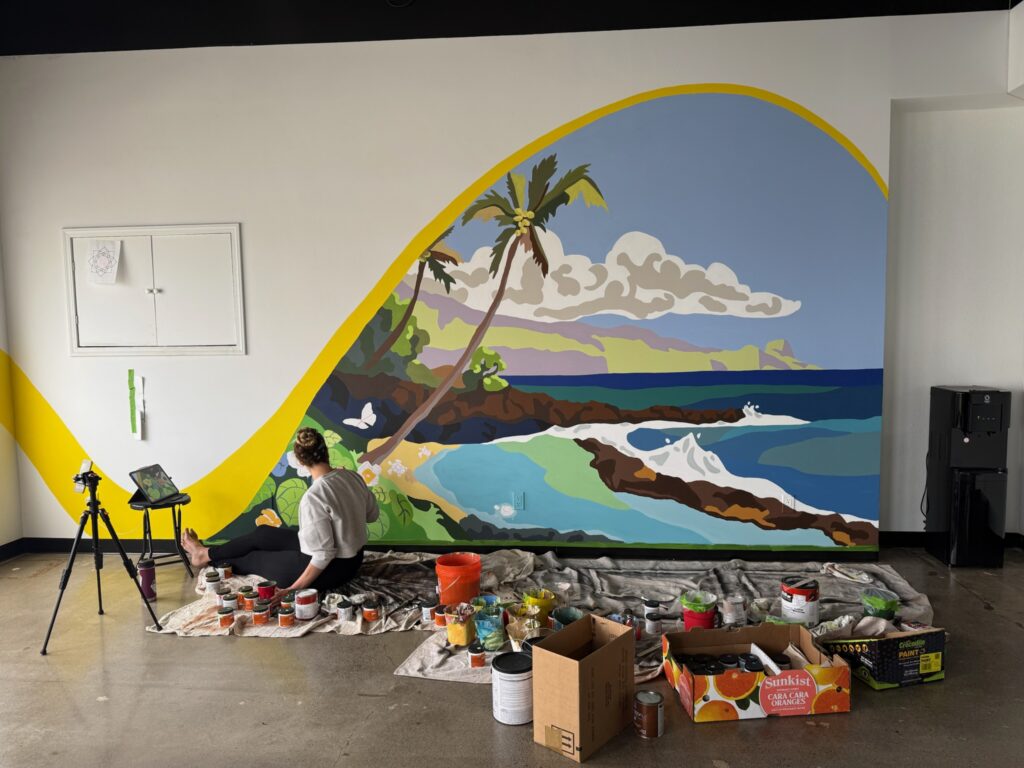 maui mural artist paints north shore maui beach scene onto wall.